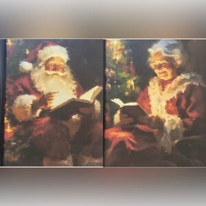 Set of 2 8x10” framed prints Santa writing in book and Mrs Claus reading a book